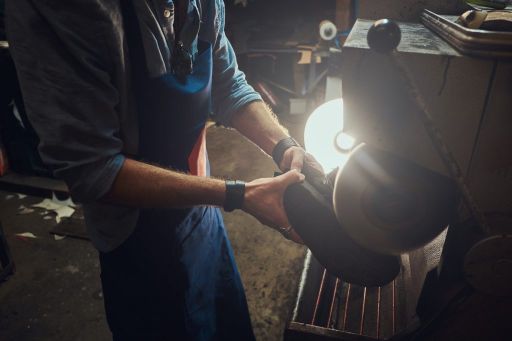 Hands of cobbler, working with mashine tool